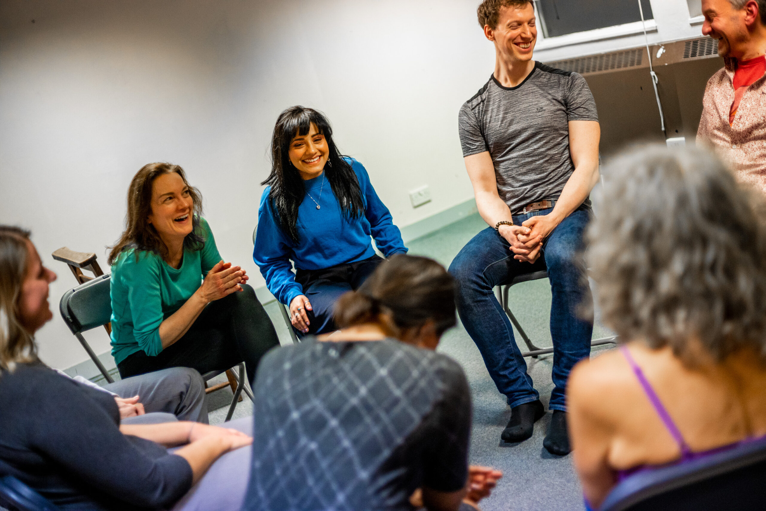 improv in the workplace session, group sits laughing during the teambuilding workshop.
